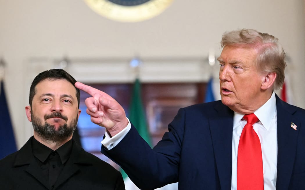 (L/R) Ukrainian President Volodymyr Zelensky and US President Donald Trump stand for a family photo with other European leaders in the Cross Hall of the White House in Washington, DC, on August 18, 2025. European leaders join Ukrainian President Volodymyr Zelensky in talks with US President Donald Trump on August 18, as they try to find a way to end Russia's offensive.  The leaders heading to Washington on Monday to appear alongside Zelensky call themselves the "coalition of the willing." (Photo by ANDREW CABALLERO-REYNOLDS / AFP)