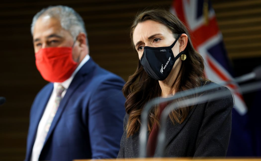 Minister Peeni Henare speaks to media while Prime Minister Jacinda Ardern looks on during a press conference at Parliament on September 02, 2021
