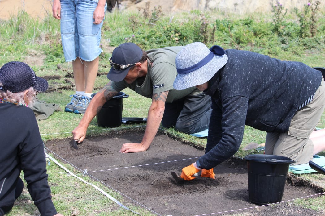 Whānau members dig out the marked excavation pit at Tikoraki point.