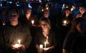 People attend a candlelight vigil to honor the victims of the Lewiston shootings on October 28, 2023 in Lisbon, Maine.