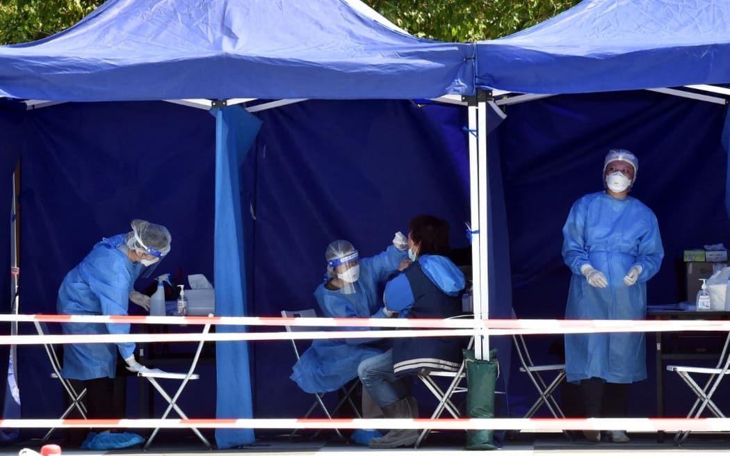 Medical workers collect samples for nucleic acid testing at a mobile testing site in Hong Kong, south China,