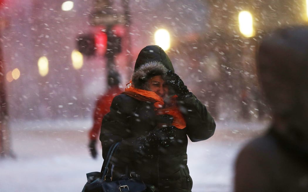 Pedestrians walk along a Manhattan street in heavy snow as New York braces for a major winter storm.