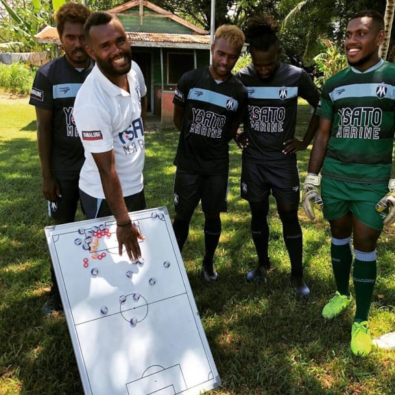 Marist FC assistant coach Jerry Sam talks tactics with the players.