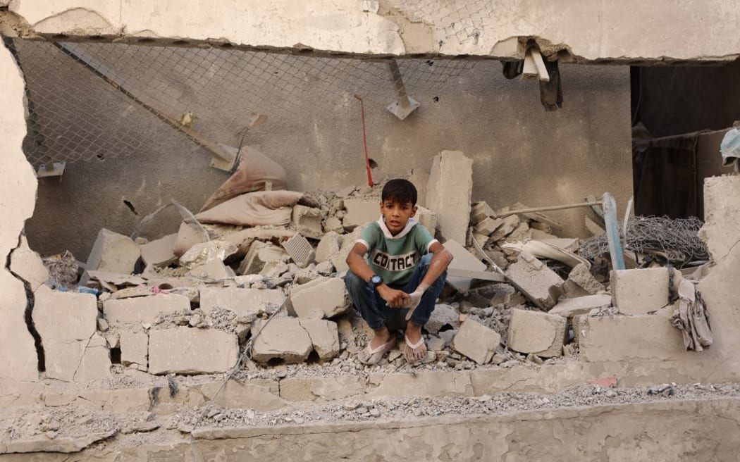 A Palestinian boy sits amongst the debris at the site of an Israeli strike on a school housing displaced Palestinians in Gaza City's Zaytoun neighbourhood on September 21, 2024. Gaza's civil defence agency said an Israeli strike on a school-turned-shelter in the Palestinian territory's largest city killed 19 people, while Israel's military said it targeted Hamas militants. (Photo by Omar AL-QATTAA / AFP)