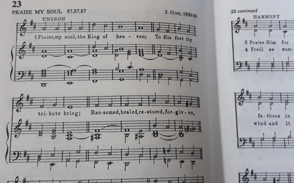 Pages of a hymn book, open at Praise, my soul, the King of heaven