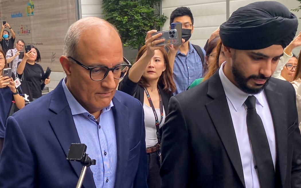 Singapore's Minister for Transport and Minister-in-charge for Trade Relations S. Iswaran (L) leaves the State Court in Singapore on January 18, 2024. Singapore's prime minister announced on January 18 the resignation of his transport chief Iswaran after he was charged with 27 offences in a corruption probe that has also ensnared a billionaire hotel tycoon. Iswaran said he would plead not guilty to the charges filed by the Corrupt Practices Investigation Bureau when he appeared in court. (Photo by Catherine LAI / AFP)