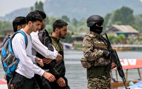An Indian paramilitary personnel stands guard along the banks of Dal Lake in Srinagar on May 6, 2025. Nuclear-armed rivals India and Pakistan have exchanged gunfire for 12 consecutive nights across their heavily militarised de facto border in the contested Kashmir region since an April 22 attack that killed 26 civilians, which New Delhi blames on Pakistan, claims Islamabad denies. (Photo by Sajjad HUSSAIN / AFP)