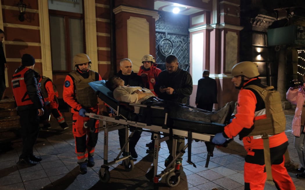 Rescuers evacuate a wounded person following a Russian missile attack in Odesa on January 31, 2025, amid the Russian invasion of Ukraine. A Russian missile attack struck a five-star hotel in the Ukraine's Black Sea port city of Odesa, wounding two women, the mayor said. (Photo by Oleksandr GIMANOV / AFP)