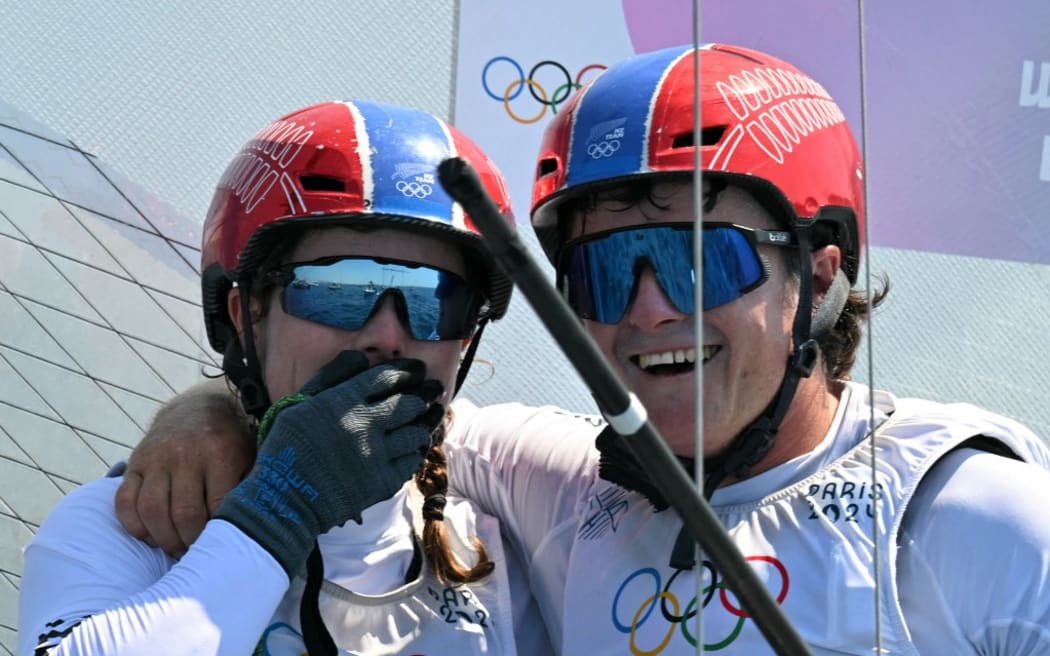 Bronze medallists New Zealand's Micah Wilkinson and Erica Dawson celebrate after the medal race of the mixed Nacra 17 multihull event during the Paris 2024 Olympic Games sailing competition at the Roucas-Blanc Marina in Marseille on August 8, 2024. (Photo by NICOLAS TUCAT / AFP)