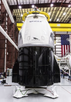 SpaceX's Crew Dragon spacecraft and Falcon 9 rocket are positioned inside the company's hangar at Launch Complex 39A at NASA's Kennedy Space Center in Florida.