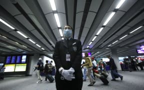 A health worker stands by ready for temperature screening of travellers on April 27, 2009 at the international airport in Hong Kong.