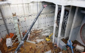 The tunnel is half complete. Workers have to dismantle the drill before it can bore its way back early next year.