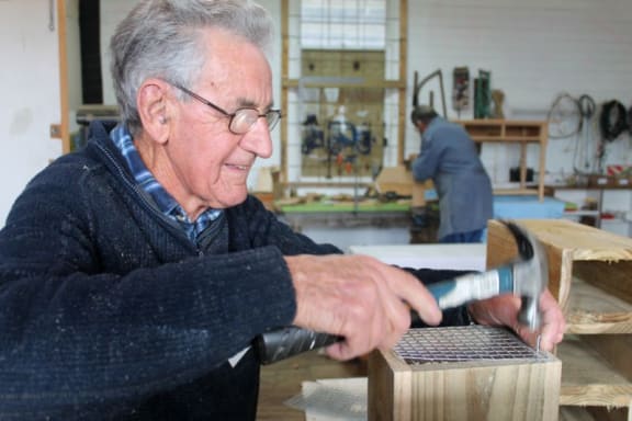 This image shows a member of the Whangarei Men's Shed building rodent traps
