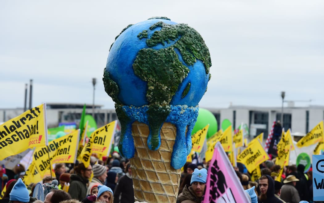 A melting planet in an ice cream cone carried during the climate change march in  Berlin, Germany.