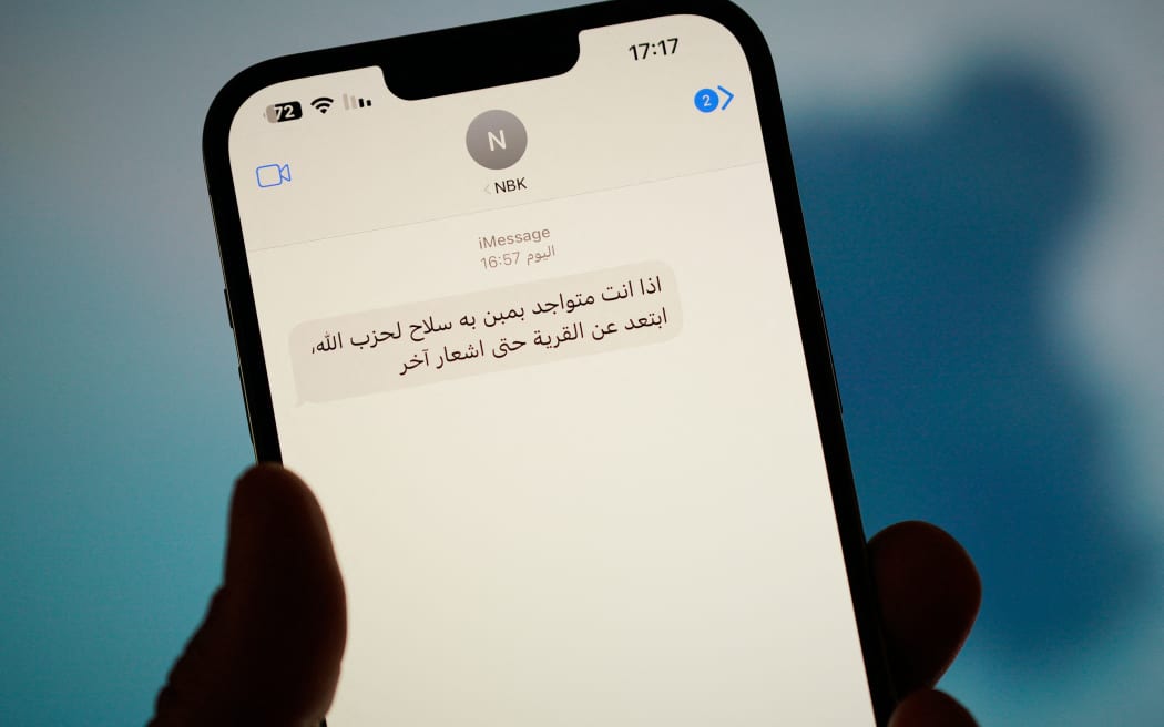A text message in Arabic calling on people to leave areas risking strikes by the Israel Defence Forces (IDF) is seen on a phone in this illustration image in Warsaw, Poland on 23 September, 2024. Isreali forces have started escalating attacks on Lebanon on Monday to hit what they say are residential areas where Hezbollah is hiding weapons including cruise missiles. The actions have been called the largest escalation by Israel since its recent attacks on Hezbollah. (Photo by Jaap Arriens/NurPhoto) (Photo by Jaap Arriens / NurPhoto / NurPhoto via AFP)