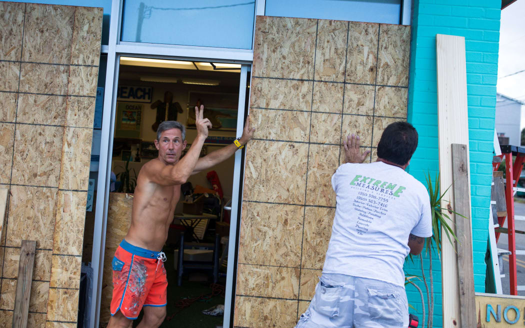 A shop owner boards up his Wrightsville Beach, North Carolina, building.