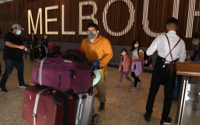 Passengers are greeted at Melbourne's international airport on February 21, 2022 as Australia opens its international borders to all vaccinated tourists, nearly two years after the island nation first imposed some of the world's strictest Covid-19 travel restrictions.