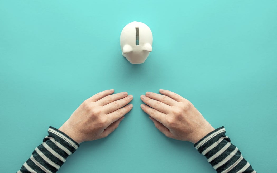 Female hands and piggy bank for. Savings concept. (Photo by IGOR STEVANOVIC / SCIENCE PHOTO / IST / Science Photo Library via AFP)