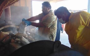 Marshall Islands Police Captain Eric Jorban, left, empties a bag of one-kilo packages of cocaine into an incinerator