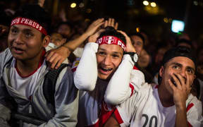 Peruvian football fans celebrate as they watch their team's 2018 World Cup football qualifier match against New Zeland on a big screen at a park in Lima, on November 10, 2017.