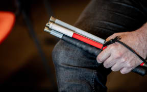 A blind person holding a cane.