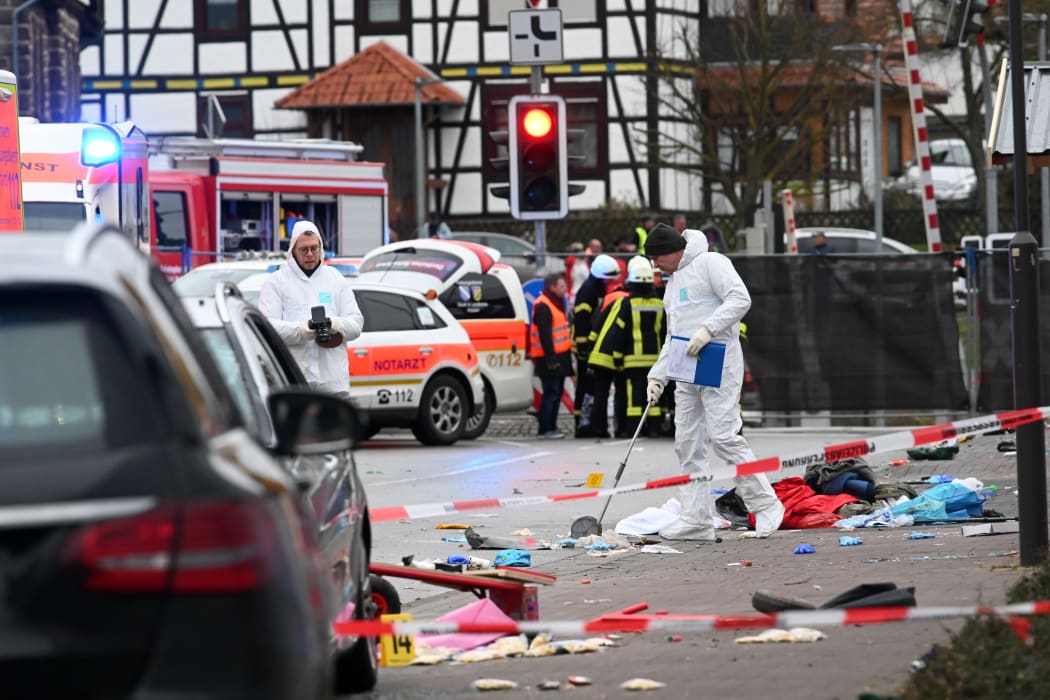 Police officers close to the site where a car drove into a carnival procession in Volkmarsen.