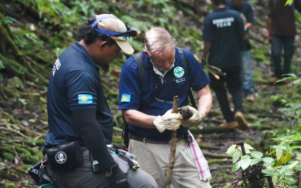 Roger Hess (right) and a member of the Norwegian People’s Aid clearance team inspect an abandoned WWII munition on Umurbrogal Mountain in Peleliu, Palau, Nov. 26, 2024.