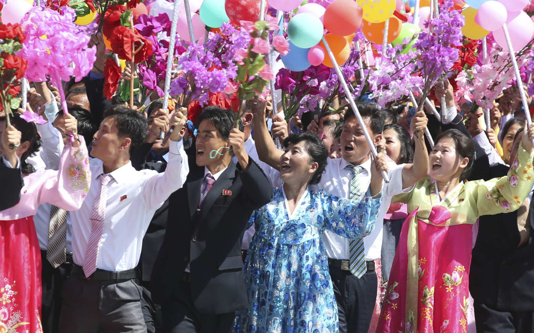 People take part in a parade to celebrate the 70th anniversary of the founding of the Democratic People's Republic of Korea (DPRK)