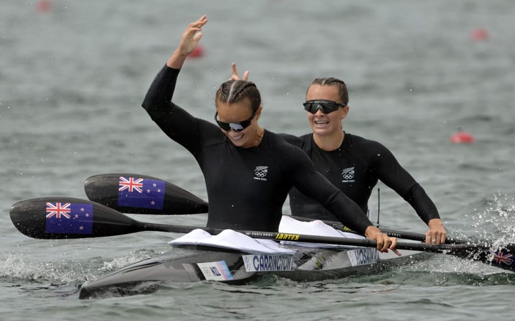 New Zealand's gold medallists Lisa Carrington and Alicia Hoskin celebrate their victory in the women's kayak double 500m final of the canoe sprint competition at Vaires-sur-Marne Nautical Stadium in Vaires-sur-Marne during the Paris 2024 Olympic Games on August 9, 2024. (Photo by Bertrand GUAY / AFP)