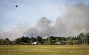 Fire nears a house at Pine Beach, just north of Christchurch.