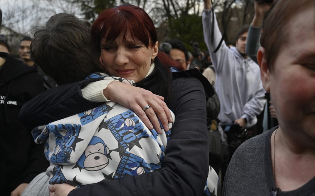 Inessa hugs her son Vitaly after the bus delivering him and more than a dozen other children back from Russian-held territory arrive in Kyiv on 22 March, 2023.