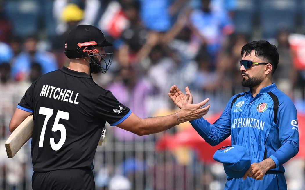 New Zealand's Daryl Mitchell (L) is congratulated by Afghanistan's captain Rashid Khan for his team's win at the end of the 2026 ICC Men's T20 Cricket World Cup group stage match between Afghanistan and New Zealand at the MA Chidambaram Stadium in Chennai on February 8, 2026. (Photo by R. Satish BABU / AFP)