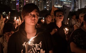 People hold candles to commemorate the Tiananmen Square anniversary.
