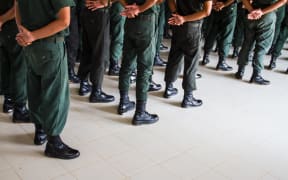 Men standing in uniform, boot camp style.