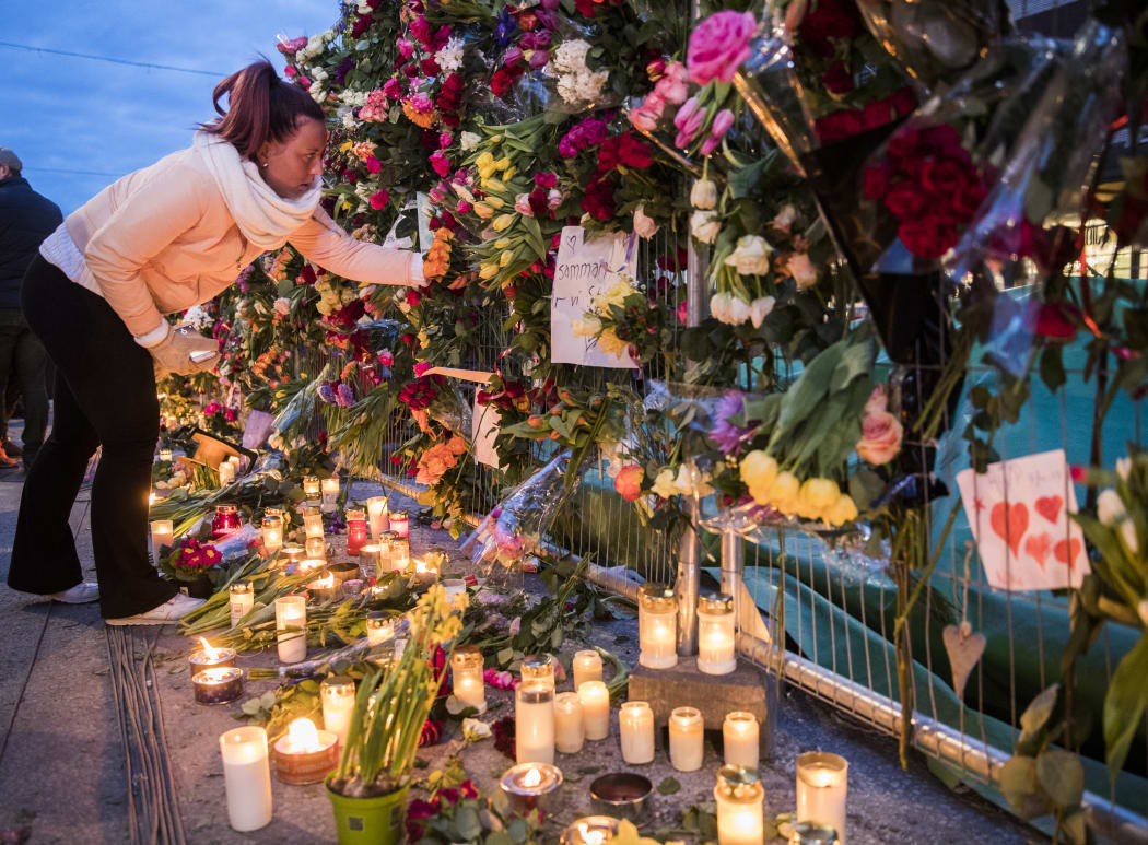 People leave tributes to those killed in an attack by the man who drove a truck through a crowd and into a storefront in Stockholm, Sweden.