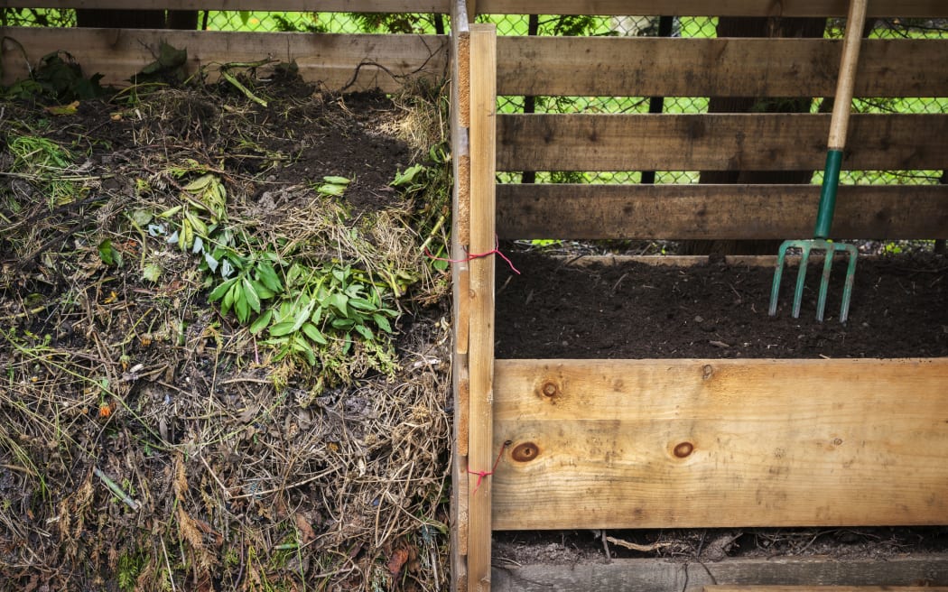 Compost boxes with composted soil and garden waste for backyard composting
