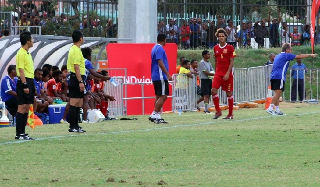 PNG defender Felix Komolong heads to the sideline after being shown a red card.