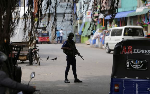 A Sri Lankan naval soldier stands guard at a road leading to a closed market on May Day in Colombo, Sri Lanka, Wednesday, May 1, 2019.