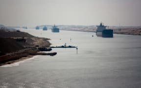 Loaded containers stacked on top of a cargo ship in sigle fine sailing in a canal on Janvier 20, 2017 in Suez Canal, Red sea, Egypt.
