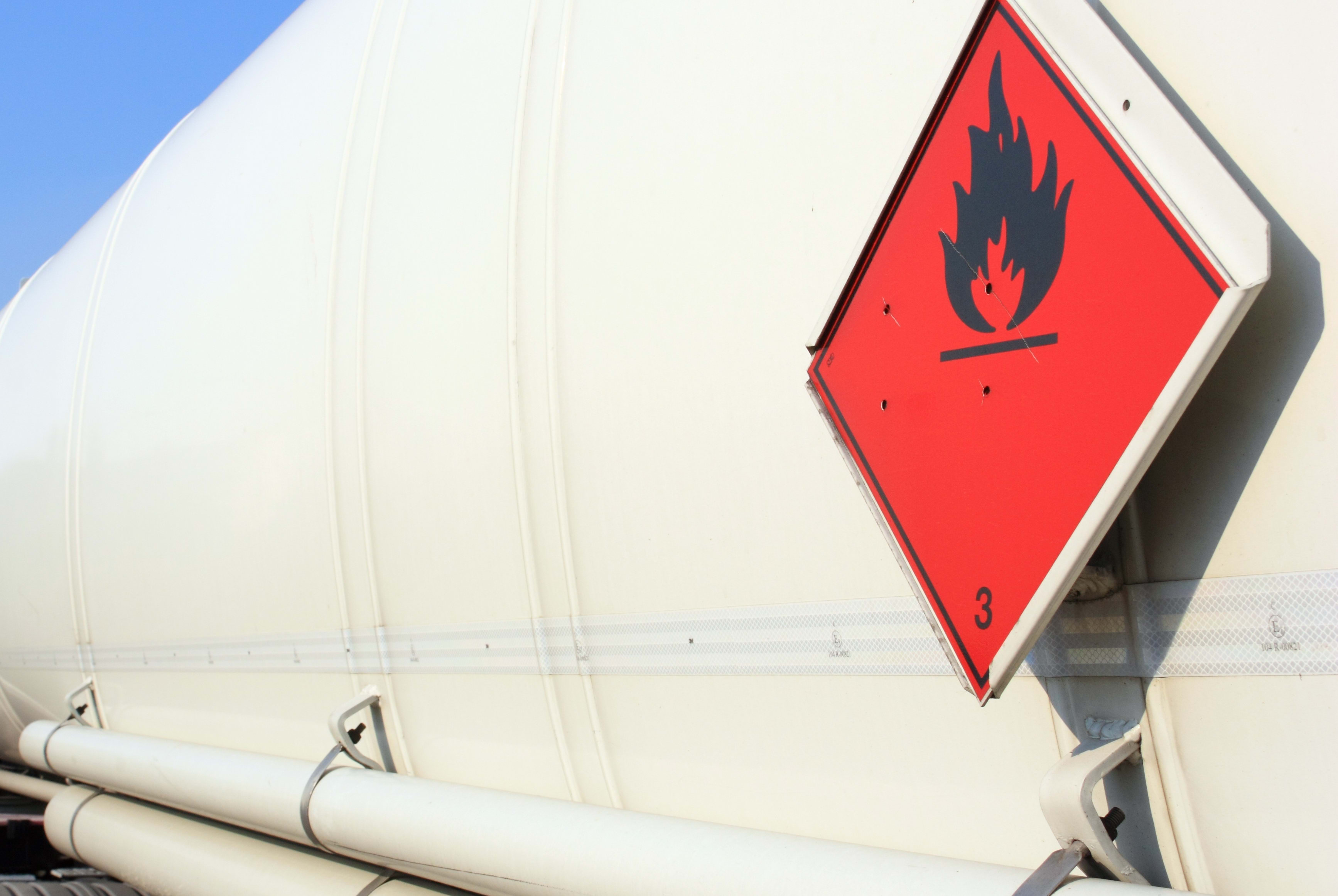 A fuel and flammable liquid tanker truck with a fire hazard warning sticker.