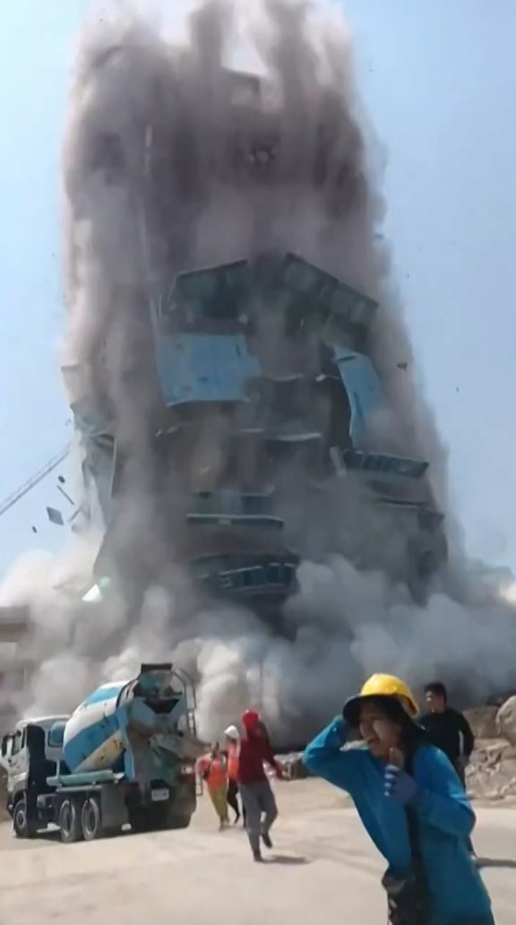 This frame grab from UGC video footage taken and posted by Khon Su Cheevit Adeet Mai Suay Rok Na on Facebook on March 28, 2025 shows workers running away from a building as it collapses at a construction site in Bangkok, following an earthquake. A powerful earthquake rocked central Myanmar on March 28, buckling roads in capital Naypyidaw, damaging buildings and forcing people to flee into the streets in neighbouring Thailand. (Photo by Handout / Courtesy of Facebook user Khon Su Cheevit Adeet Mai Suay Rok Na / AFP) / NO USE AFTER APRIL 11, 2025 12:29:17 GMT - NO USE AFTER APRIL 11, 2025 12:29:17 GMT - -----EDITORS NOTE --- RESTRICTED TO EDITORIAL USE - MANDATORY CREDIT "AFP PHOTO / COURTESY OF FACEBOOK USER KHON SU CHEEVIT ADEET MAI SUAY ROK NA " - NO MARKETING - NO ADVERTISING CAMPAIGNS - DISTRIBUTED AS A SERVICE TO CLIENTS  - NO ARCHIVES /