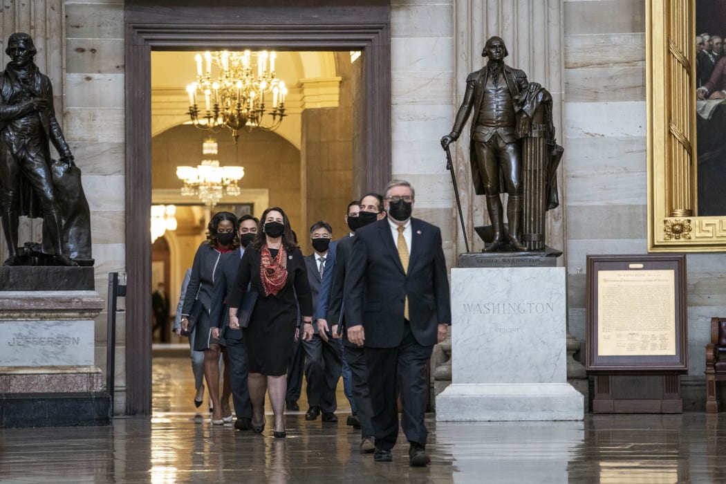 House impeachment managers proceed through the Capitol Rotunda from the House side of the US Capitol to the US Senate chamber.