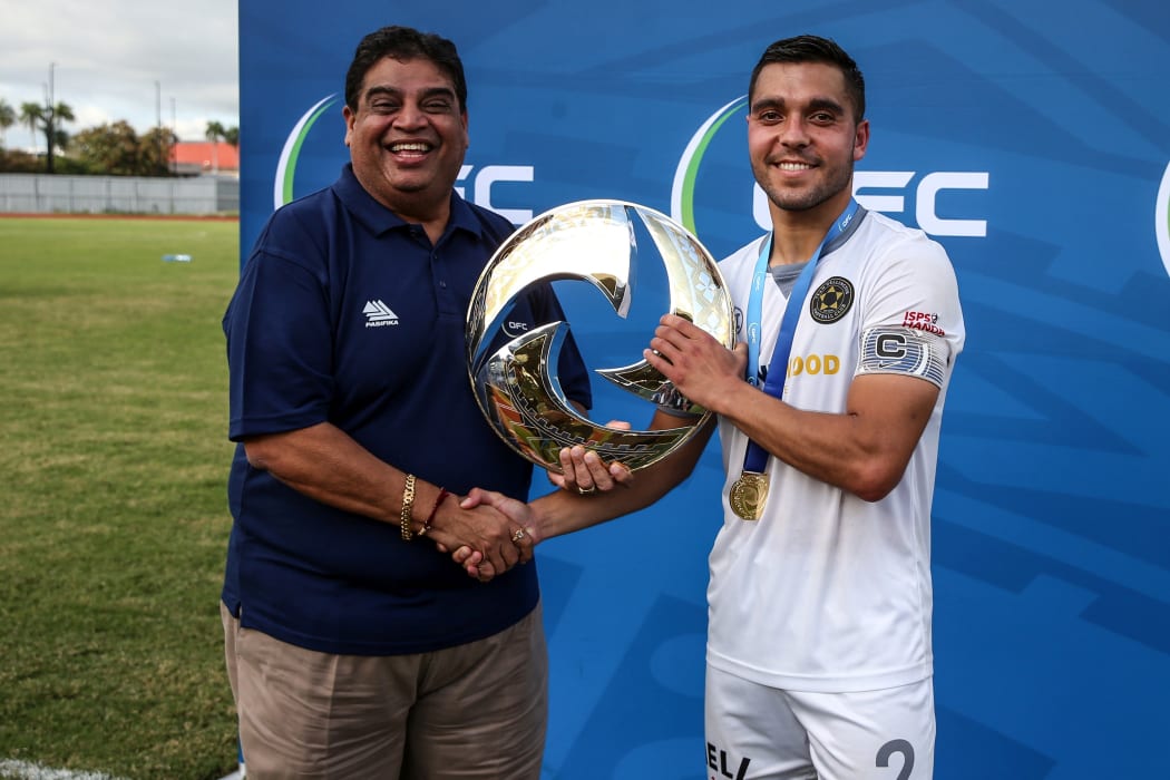 Fiji Football President Rajesh Patel presents the OFC Champions League trophy to Team Wellington's Justin Gulley.