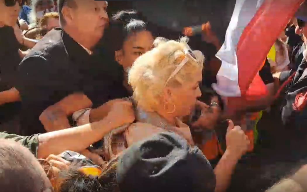 Screengrab from a video of Posie Parker being escorted out of her rally by her security.