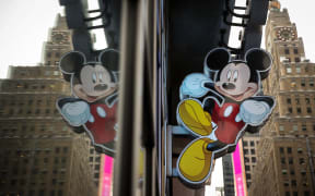An image of Mickey Mouse, the official mascot of The Walt Disney Company, is displayed outside the Disney Store in Times Square, December 14, 2017 in New York City. The Walt Disney Company announced on Thursday morning that it had reached a deal to purchase most of the assets of 21st Century Fox. The deal has a total value of around $66 billion, with Disney assuming $13.7 billion of Fox's net debt.   Drew Angerer/Getty Images/AFP (Photo by Drew Angerer / GETTY IMAGES NORTH AMERICA / Getty Images via AFP)