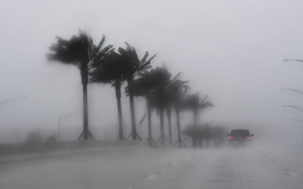 Commuters make their way through heavy rain in Jacksonville, Florida, on October 6, 2016, ahead of hurricane Matthew.