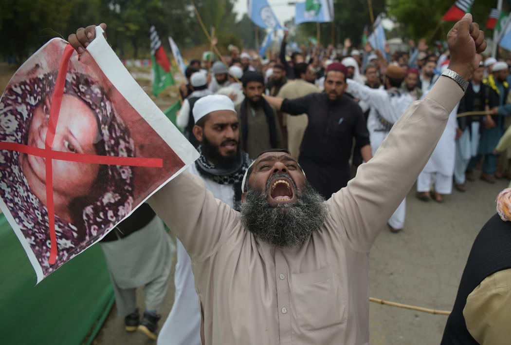 A Pakistani supporter of the Ahle Sunnat Wal Jamaat (ASWJ), a hard line religious party, holds an image of Christian woman Asia Bibi during a protest rally following the Supreme Court's decision to acquit Bibi of blasphemy.