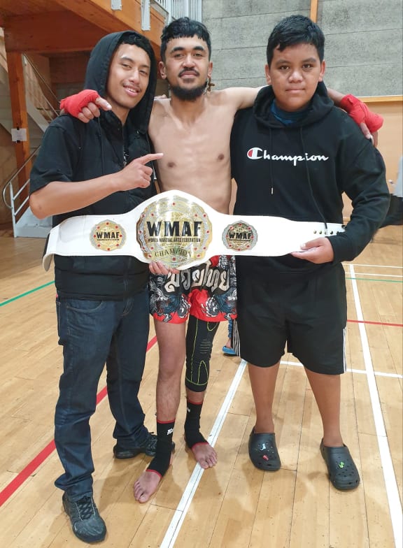 Taunga Kairena with his championship belt and peers