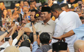 Indonesian presidential candidate Prabowo Subianto, center, shakes hands with his supporter after press conference in Jakarta, Indonesia on 17 April, 2019.