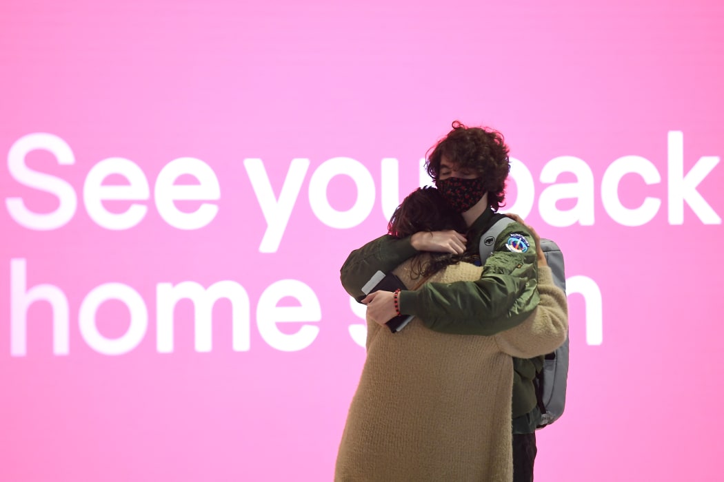 Family members embrace at the departure lounge at Sydney's International Airport on November 1, 2021, as Australia's international border reopens almost 600 days after a pandemic closure began.